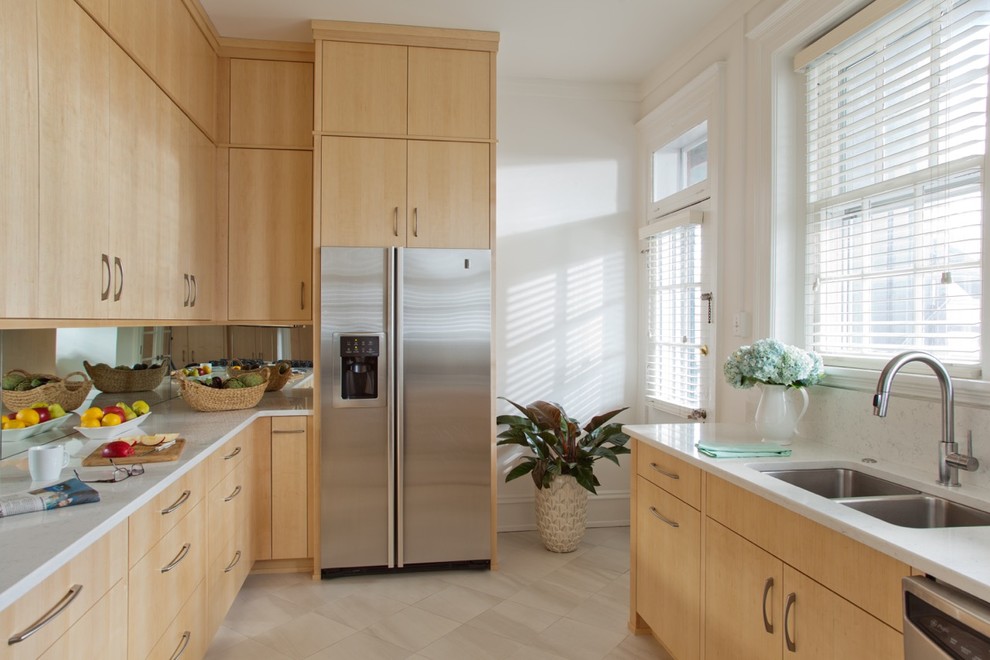 This is an example of a small modern galley separate kitchen in Richmond with an undermount sink, flat-panel cabinets, light wood cabinets, quartz benchtops, mirror splashback, stainless steel appliances, ceramic floors and no island.