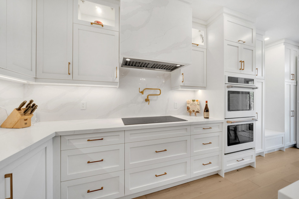 Idéer för att renovera ett stort funkis vit vitt kök, med en rustik diskho, skåp i shakerstil, vita skåp, bänkskiva i kvarts, vitt stänkskydd, vita vitvaror, mellanmörkt trägolv, en köksö och gult golv