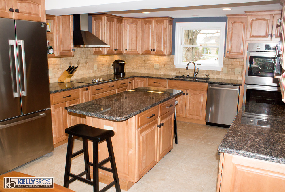 Example of a large transitional l-shaped ceramic tile eat-in kitchen design in Cincinnati with an undermount sink, raised-panel cabinets, light wood cabinets, granite countertops, beige backsplash, stone tile backsplash, stainless steel appliances and an island