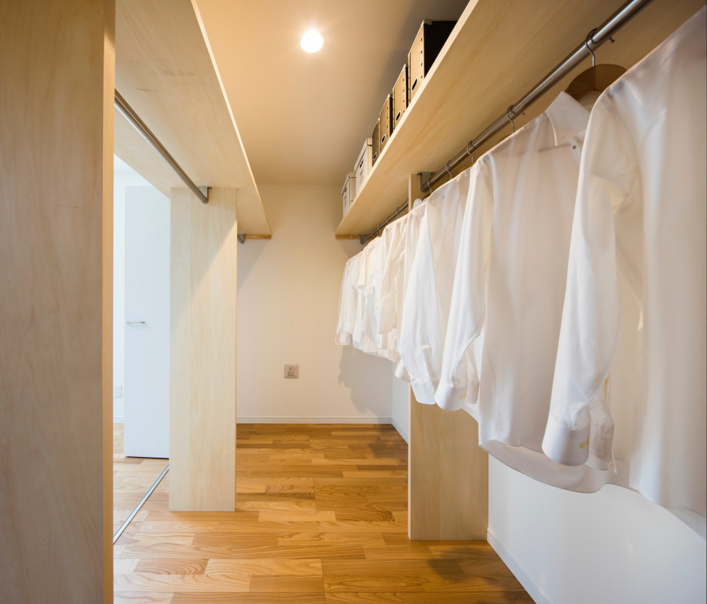 Foto på ett mellanstort funkis walk-in-closet för könsneutrala, med öppna hyllor, ljust trägolv och beiget golv