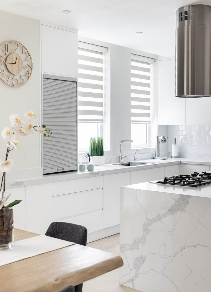 Mid-sized contemporary l-shaped eat-in kitchen in Other with flat-panel cabinets, white cabinets, white splashback, with island, white benchtop and quartz benchtops.