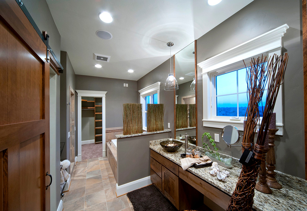 Inspiration for a small country master bathroom in Other with a vessel sink, shaker cabinets, medium wood cabinets, granite benchtops, a drop-in tub, an open shower, a one-piece toilet, beige tile, stone tile, grey walls and travertine floors.