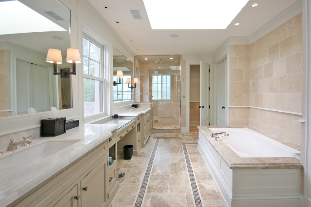Design ideas for a large traditional master bathroom in Chicago with beige cabinets, recessed-panel cabinets, an undermount tub, a corner shower, beige tile, marble floors, beige walls, an undermount sink, marble benchtops, limestone and grey benchtops.