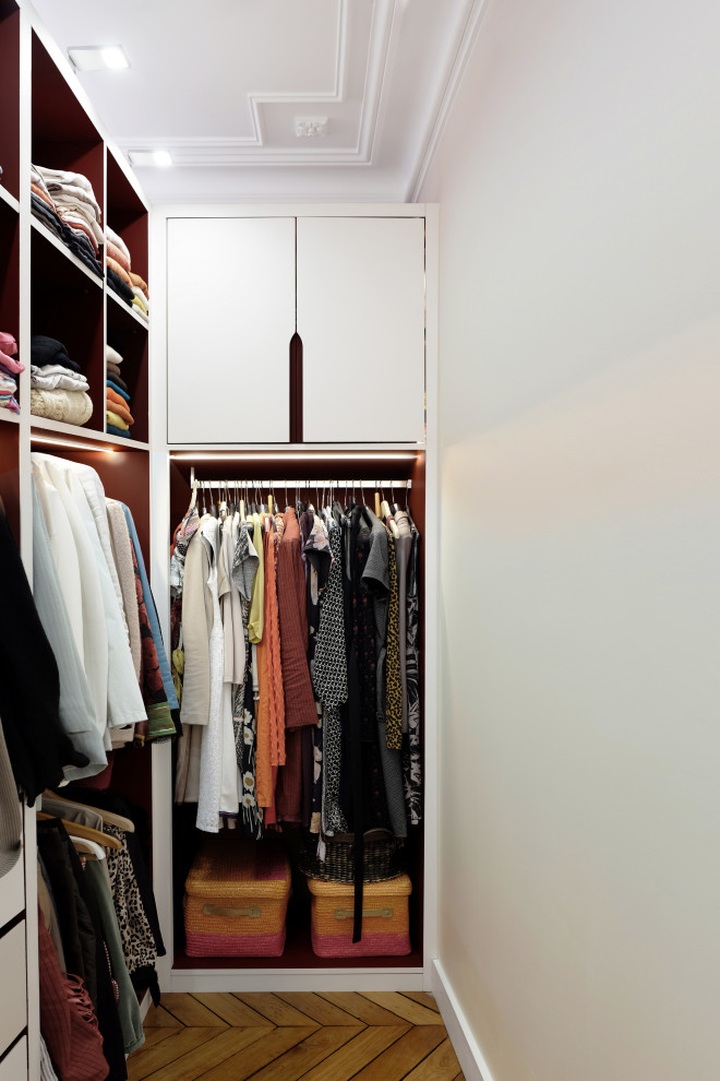 Photo of a mid-sized contemporary storage and wardrobe in Paris with light hardwood floors.