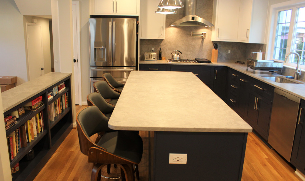 Example of a large transitional u-shaped light wood floor kitchen pantry design in DC Metro with recessed-panel cabinets, blue cabinets, granite countertops, gray backsplash, ceramic backsplash, stainless steel appliances and an island