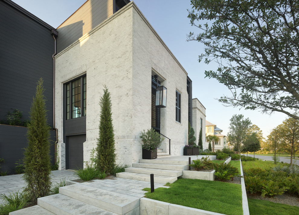 Cette image montre une grande façade de maison blanche minimaliste en brique à deux étages et plus avec un toit plat, un toit en métal et un toit noir.