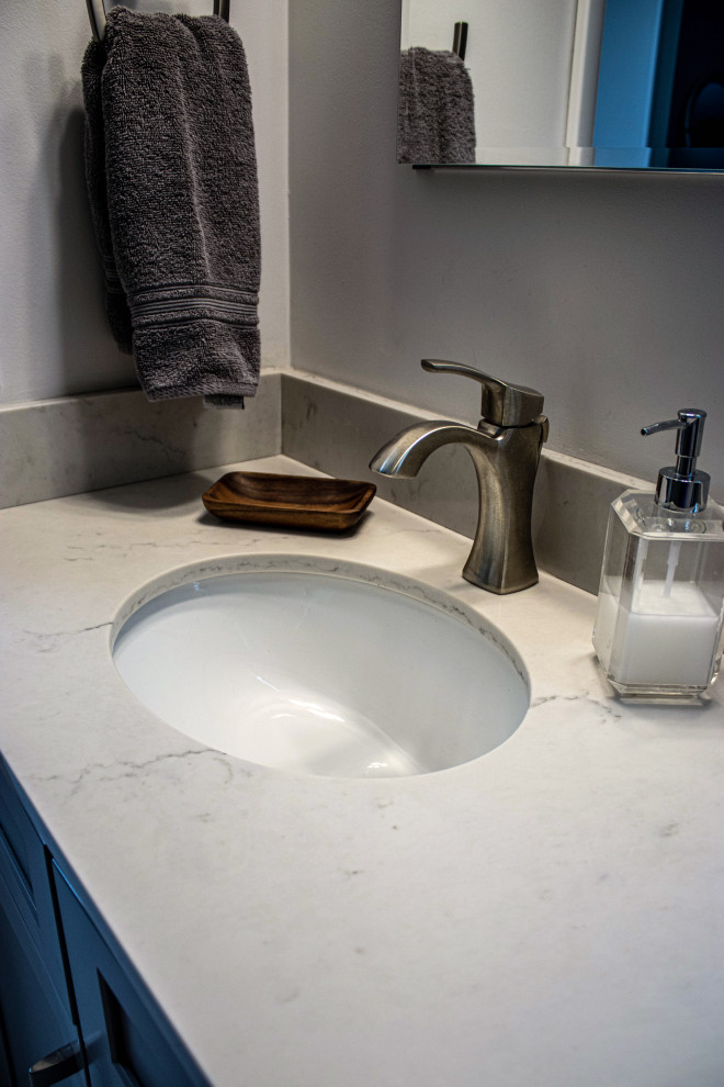 Bild på ett litet vintage beige beige en-suite badrum, med släta luckor, grå skåp, en dusch i en alkov, en toalettstol med separat cisternkåpa, vit kakel, beige väggar, klinkergolv i keramik, bänkskiva i kvarts, vitt golv och dusch med skjutdörr