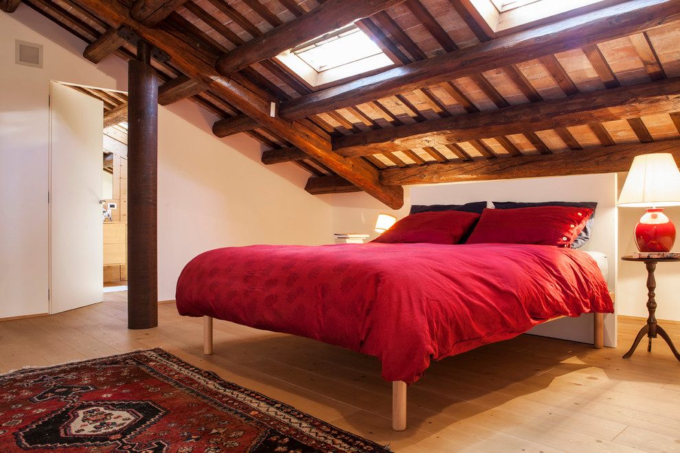 This is an example of a small country master bedroom in Venice with white walls, light hardwood floors and beige floor.