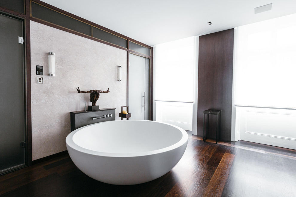 Design ideas for a large contemporary master bathroom in London with dark hardwood floors and a freestanding tub.