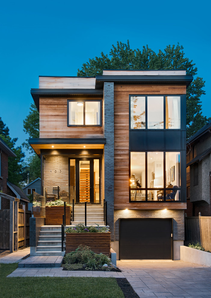 This is an example of a contemporary two-storey brown house exterior in Ottawa with wood siding and a flat roof.