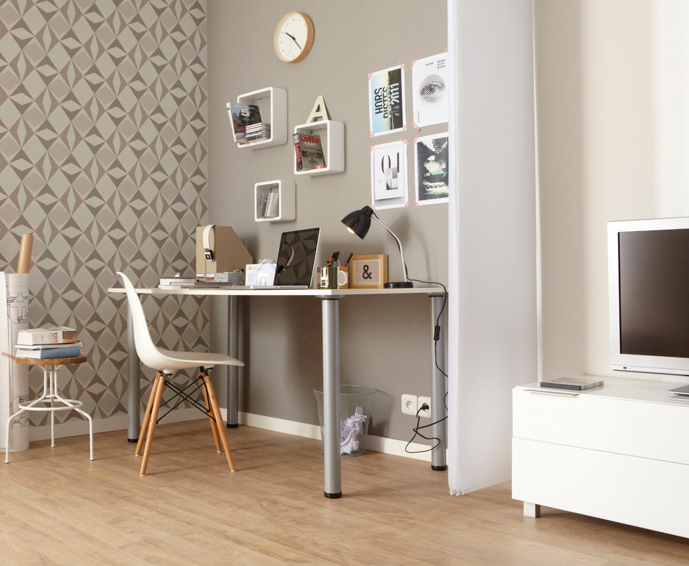 This is an example of a mid-sized contemporary study room in Lille with beige walls, light hardwood floors, no fireplace and a freestanding desk.