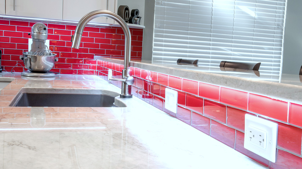 This is an example of a large modern l-shaped eat-in kitchen in Vancouver with an undermount sink, flat-panel cabinets, white cabinets, quartzite benchtops, red splashback, glass tile splashback, stainless steel appliances, linoleum floors and with island.