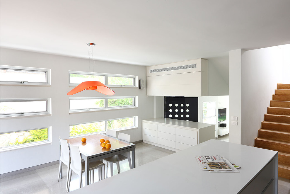 This is an example of a small modern kitchen/dining combo in Tel Aviv with white walls, limestone floors and no fireplace.