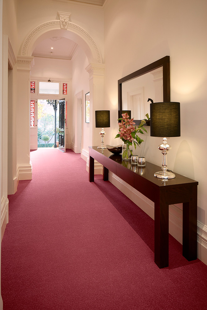 This is an example of a large contemporary hallway in Melbourne with white walls and carpet.