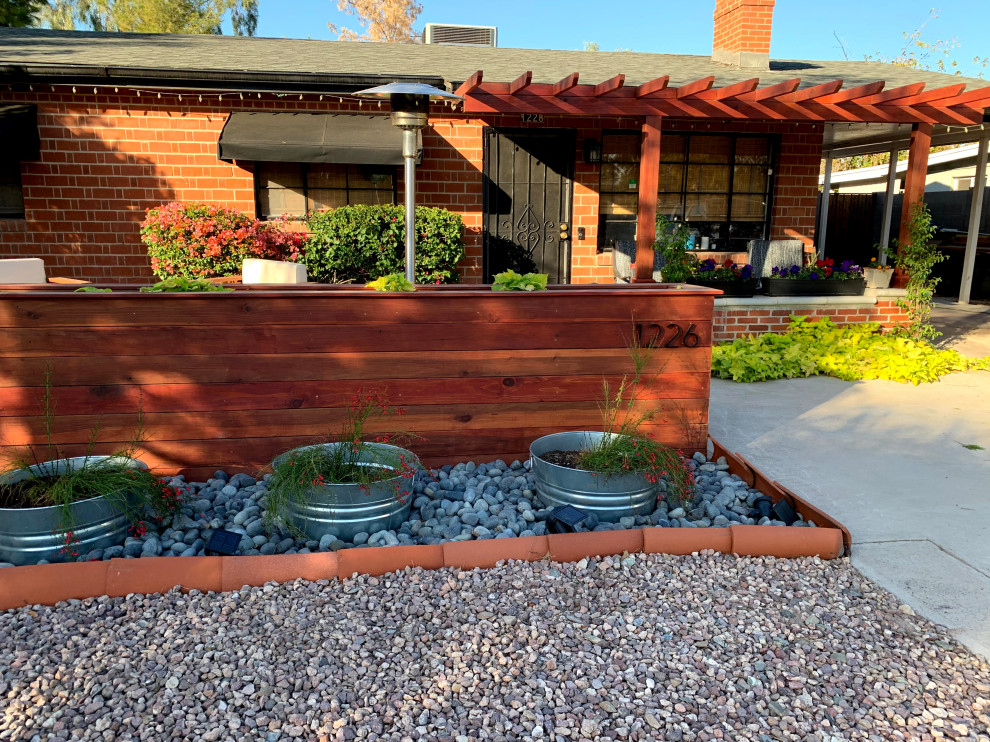 Large contemporary front yard verandah in Phoenix with a container garden, natural stone pavers, a pergola and wood railing.