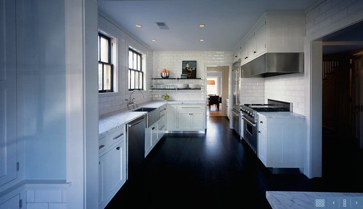 Design ideas for a contemporary galley separate kitchen in Minneapolis with a farmhouse sink, recessed-panel cabinets, white cabinets, marble benchtops, white splashback, subway tile splashback, stainless steel appliances, painted wood floors and no island.