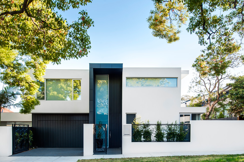 Photo of a small modern two-storey stucco black exterior in Melbourne with a flat roof.