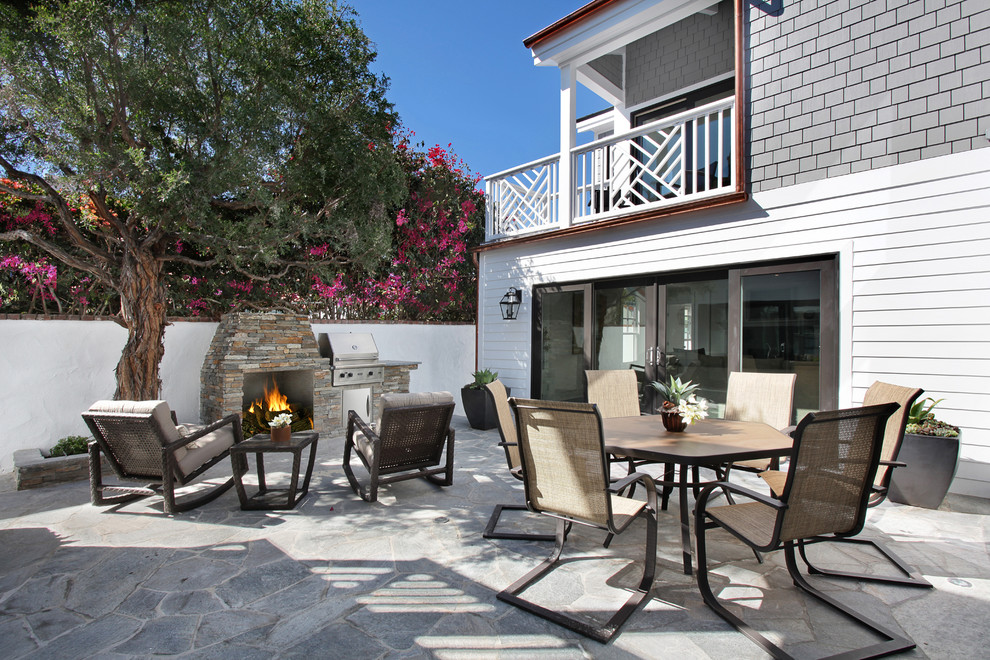 Inspiration for a beach style patio in Orange County with natural stone pavers and no cover.