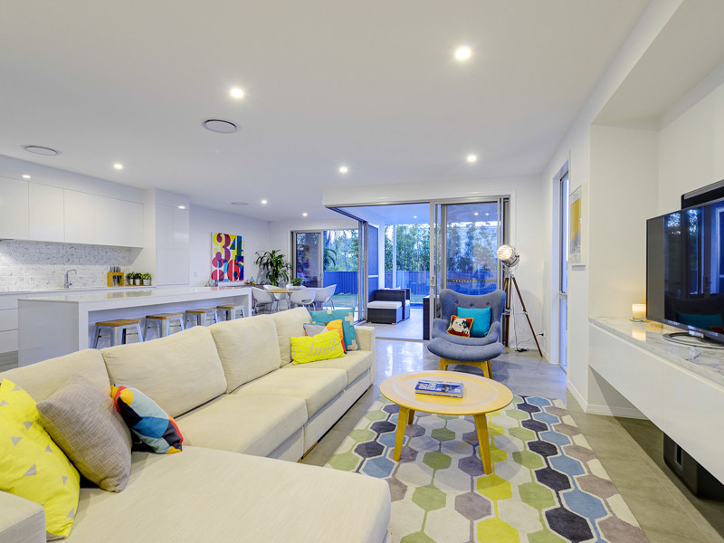 Photo of a mid-sized contemporary open concept living room in Brisbane with white walls, porcelain floors and a freestanding tv.