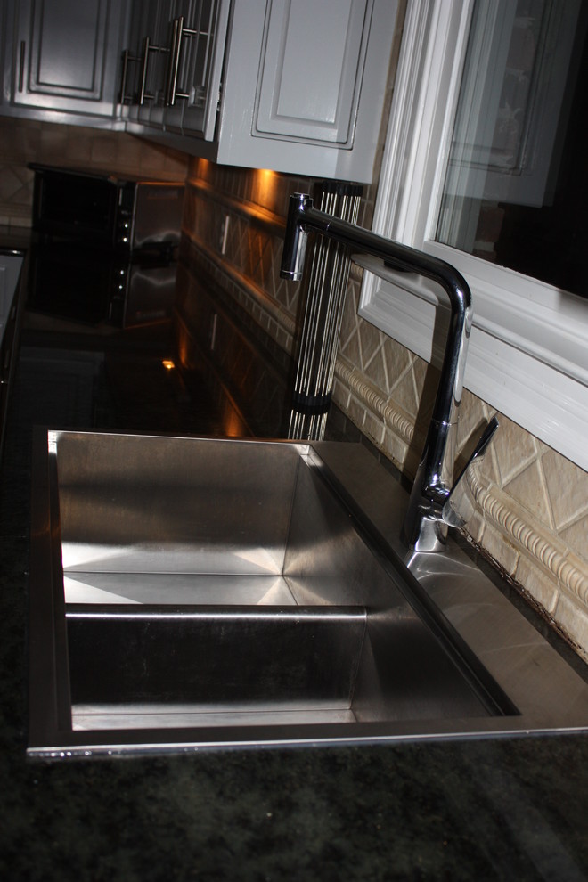Eat-in kitchen - large transitional u-shaped light wood floor eat-in kitchen idea with a double-bowl sink, raised-panel cabinets, gray cabinets, quartz countertops, beige backsplash, ceramic backsplash, stainless steel appliances and an island
