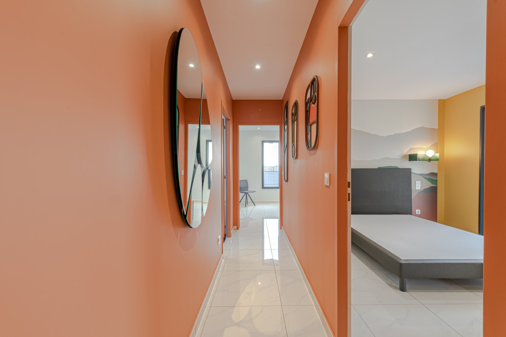 Esempio di un ingresso o corridoio minimalista di medie dimensioni con pareti arancioni, pavimento con piastrelle in ceramica e pavimento beige