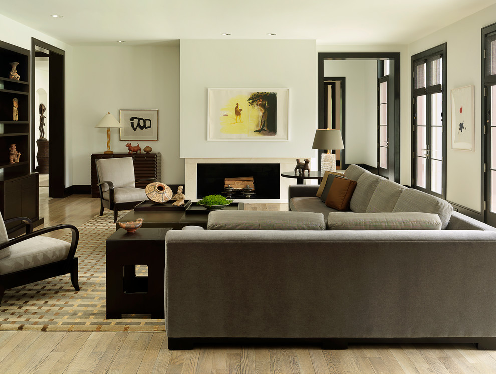 Inspiration for a transitional formal enclosed living room in St Louis with white walls, light hardwood floors, a ribbon fireplace and beige floor.
