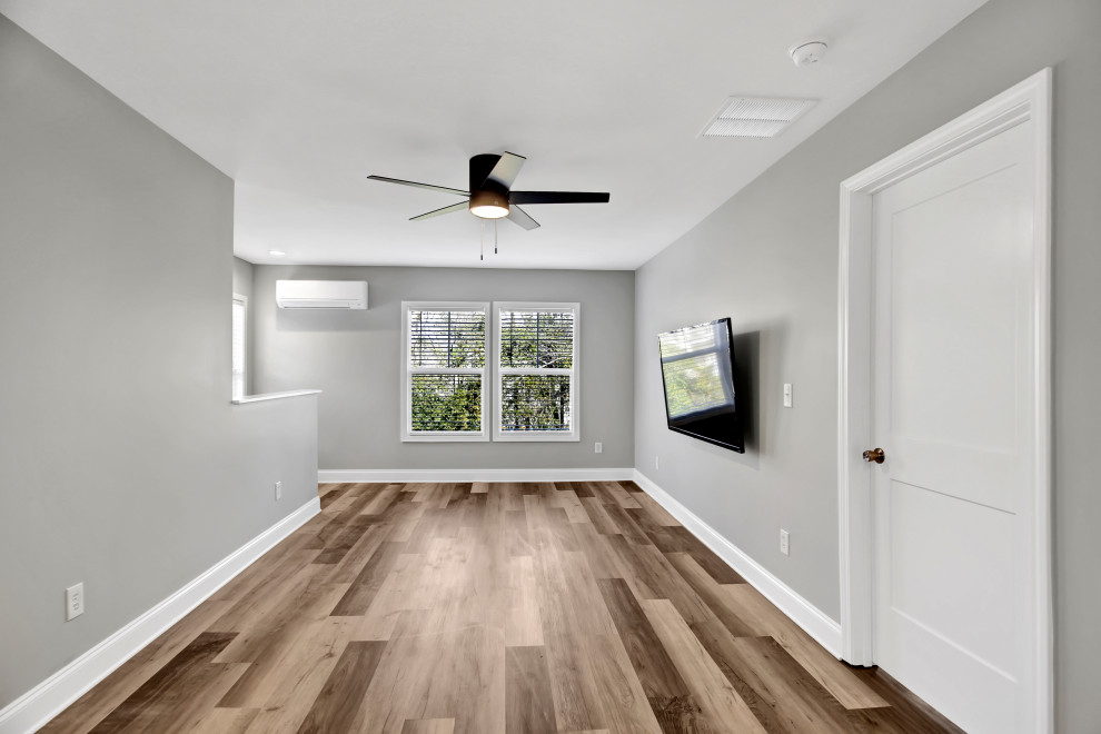 Photo of a small farmhouse open plan living room in Atlanta with grey walls, laminate floors and a wall mounted tv.