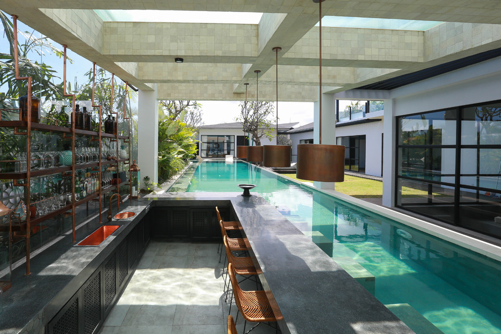 This is an example of a tropical backyard rectangular lap pool in San Diego.
