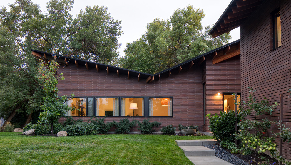 Inspiration for a mid-sized contemporary purple split-level brick house exterior remodel in Salt Lake City with a butterfly roof and a green roof