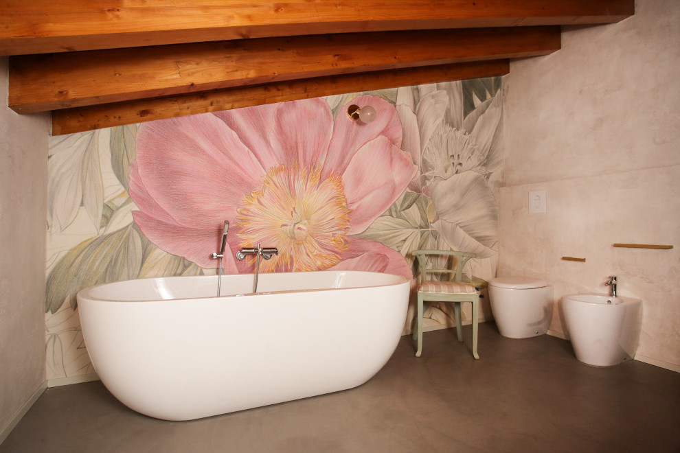 Esempio di una stanza da bagno padronale design di medie dimensioni con vasca freestanding, WC monopezzo, pareti rosa, pavimento grigio, travi a vista e carta da parati