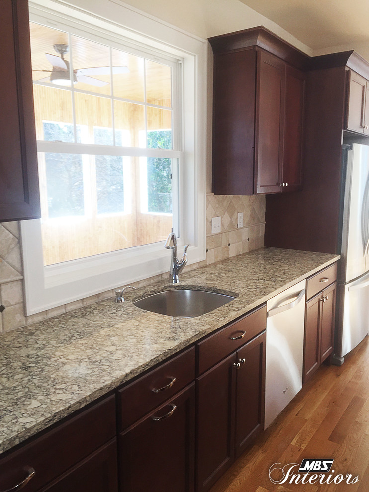Large transitional medium tone wood floor eat-in kitchen photo in Cincinnati with an undermount sink, recessed-panel cabinets, dark wood cabinets, quartz countertops, beige backsplash, stone tile backsplash, stainless steel appliances and an island