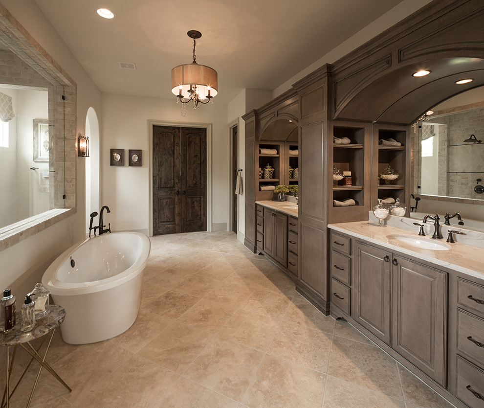 Design ideas for a mediterranean master wet room bathroom in Austin with medium wood cabinets, a freestanding tub, white walls, beige floor, an open shower, raised-panel cabinets, an undermount sink and white benchtops.