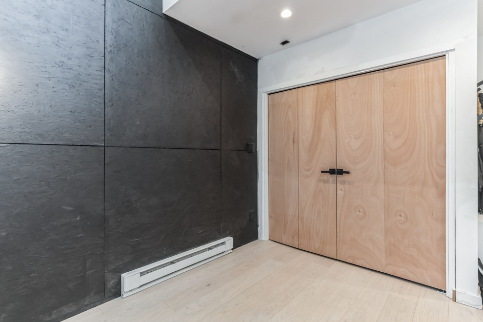 Modern inredning av en mellanstor ingång och ytterdörr, med svarta väggar, vinylgolv, en dubbeldörr, mellanmörk trädörr och beiget golv