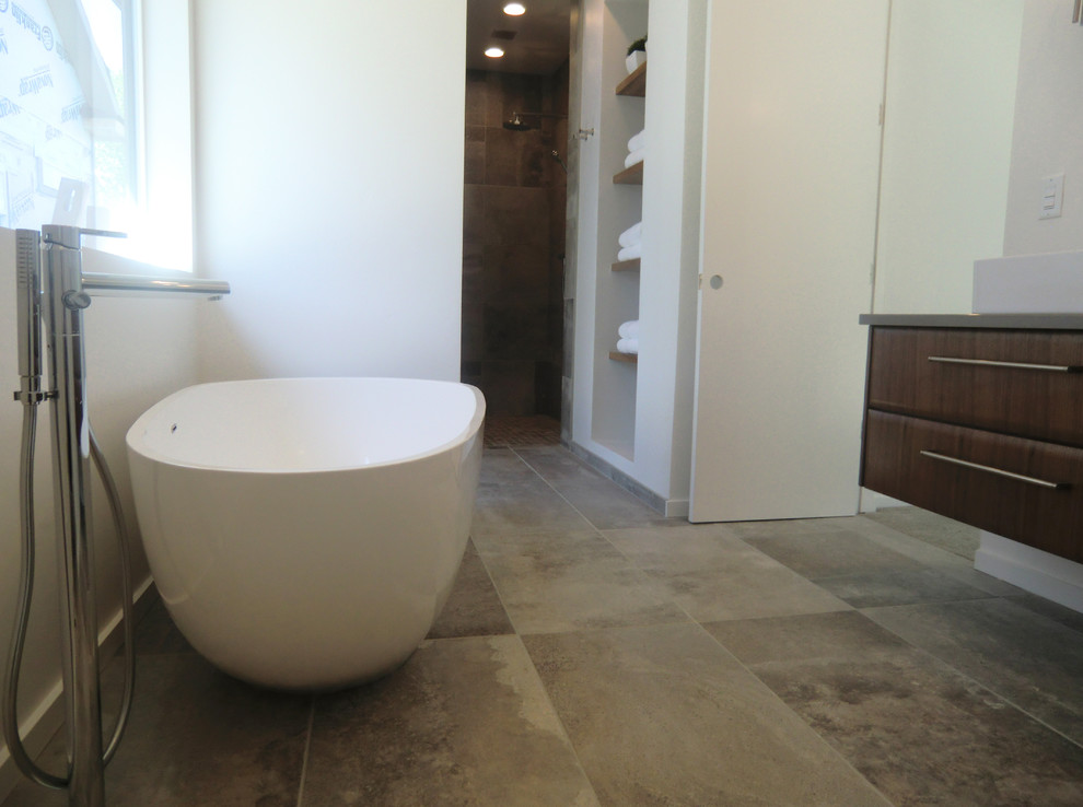 Photo of a large contemporary master bathroom in Boise with flat-panel cabinets, medium wood cabinets, a freestanding tub, an open shower, a wall-mount toilet, white walls, porcelain floors, a vessel sink, quartzite benchtops, grey floor, an open shower and grey benchtops.