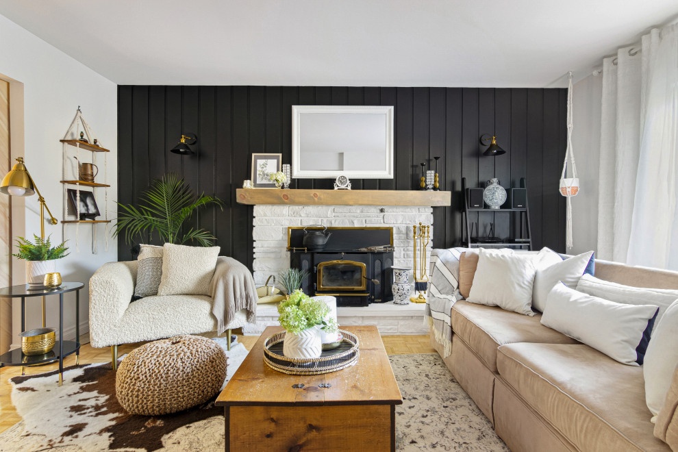 Idee per un soggiorno classico di medie dimensioni con pareti nere, cornice del camino in pietra, pavimento marrone e pannellatura