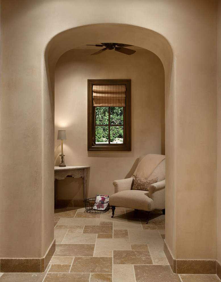 Inspiration for a mid-sized mediterranean master bathroom in Phoenix with beige tile, stone tile, beige walls, limestone floors, raised-panel cabinets, dark wood cabinets, an undermount tub, an alcove shower, a one-piece toilet, an undermount sink and limestone benchtops.
