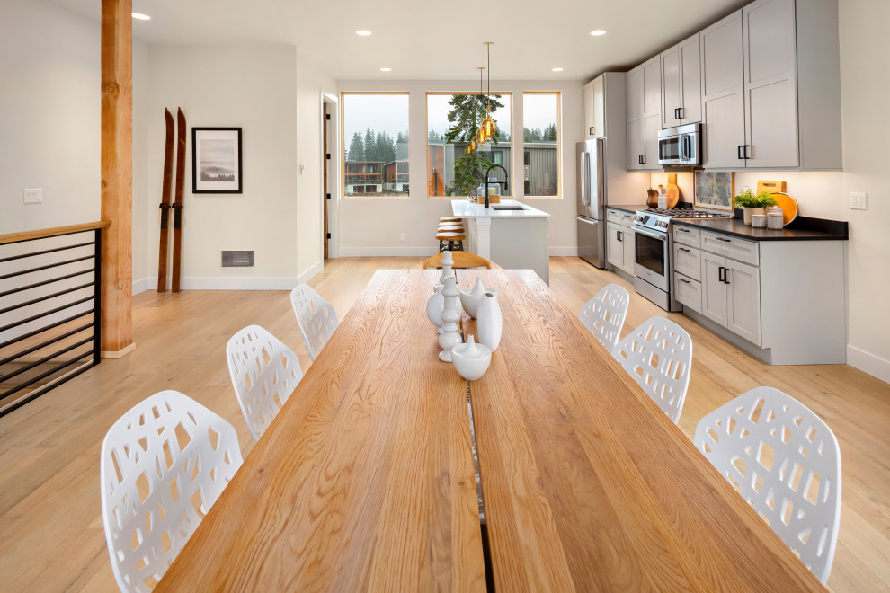 Inspiration for a contemporary dining room in Seattle with white walls and light hardwood floors.