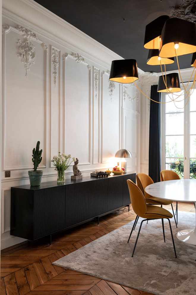 Idées déco pour une salle à manger contemporaine avec un mur blanc, un sol en bois brun, un sol marron et du lambris.