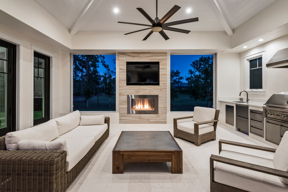 Photo of a large transitional backyard patio in Miami with a fire feature, tile and a roof extension.