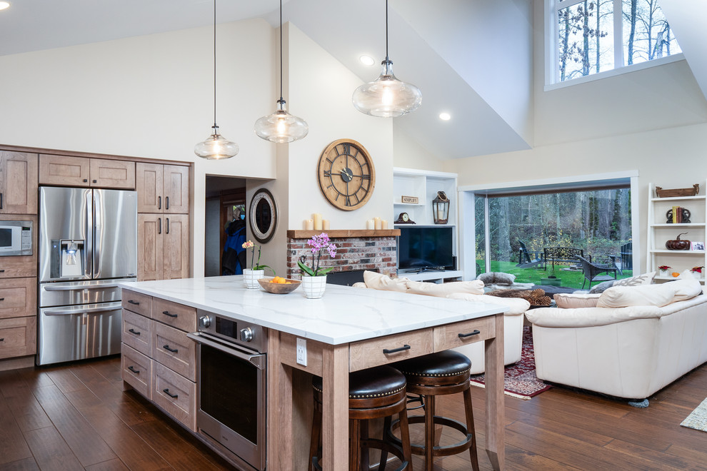 Example of a large transitional l-shaped medium tone wood floor and brown floor open concept kitchen design in Seattle with an undermount sink, shaker cabinets, light wood cabinets, quartz countertops, white backsplash, porcelain backsplash, stainless steel appliances, an island and white countertops