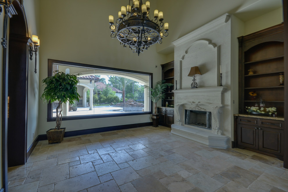 Inspiration for a mid-sized mediterranean formal living room in Houston with beige walls, marble floors, a standard fireplace, a stone fireplace surround and beige floor.