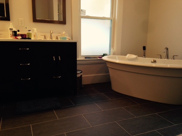 Freestanding bathtub - mid-sized transitional master gray tile and porcelain tile porcelain tile freestanding bathtub idea in Boston with an undermount sink, flat-panel cabinets, dark wood cabinets and marble countertops