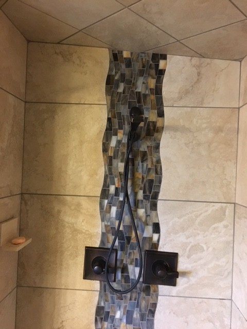 Photo of a mid-sized contemporary 3/4 bathroom in Chicago with an alcove shower, beige tile, mosaic tile, beige walls and pebble tile floors.
