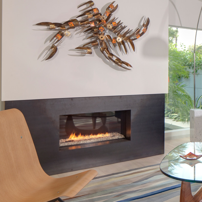 Contemporary open concept family room in New York with white walls, a ribbon fireplace and a metal fireplace surround.