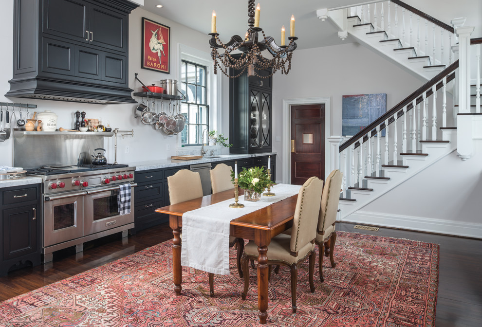 Elegant single-wall dark wood floor and brown floor eat-in kitchen photo with recessed-panel cabinets, black cabinets, stainless steel appliances and no island