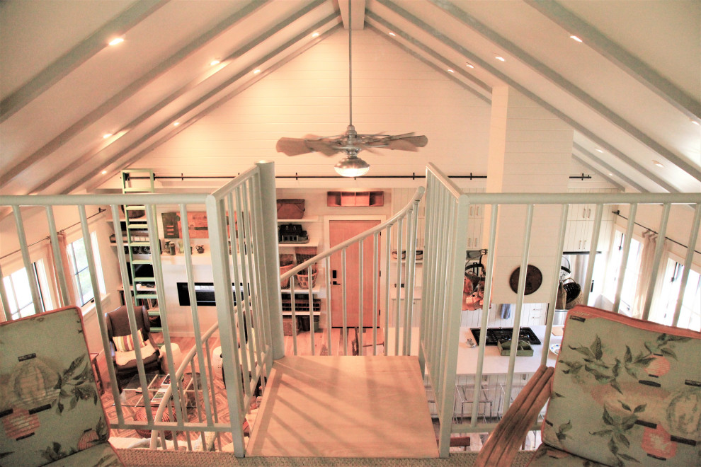 Foto de escalera de caracol campestre con escalones de madera, contrahuellas de metal, barandilla de metal y machihembrado