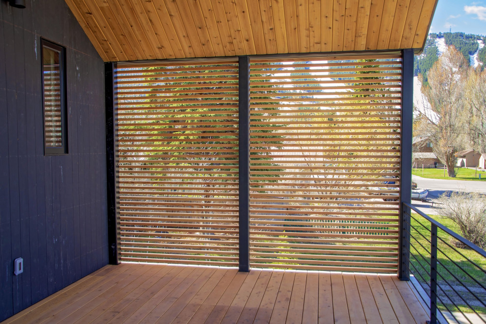 Inspiration for a backyard privacy deck remodel with a roof extension