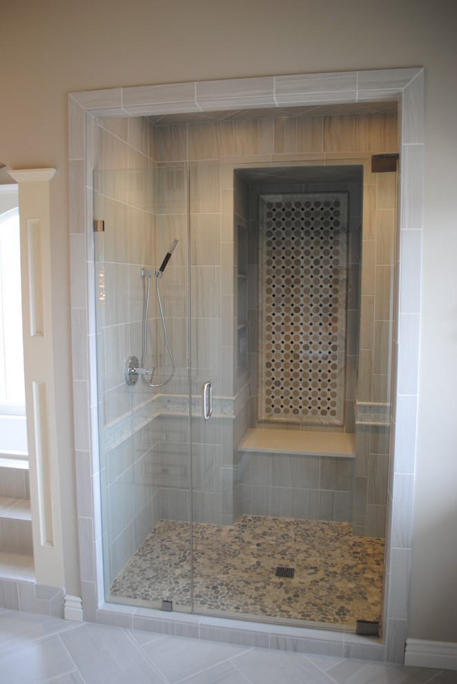 Photo of a large contemporary master wet room bathroom in Wichita with pebble tile floors, tile benchtops and a hinged shower door.