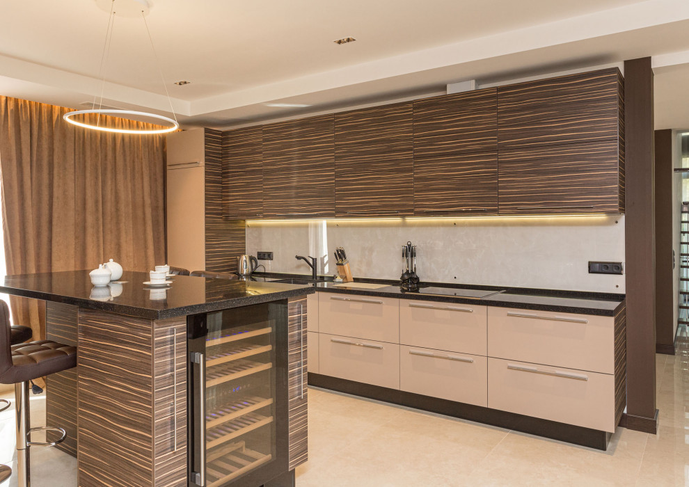 Photo of an expansive contemporary galley open plan kitchen in Saint Petersburg with a single-bowl sink, flat-panel cabinets, beige cabinets, solid surface benchtops, black appliances, porcelain floors, with island, beige floor, black benchtop and recessed.