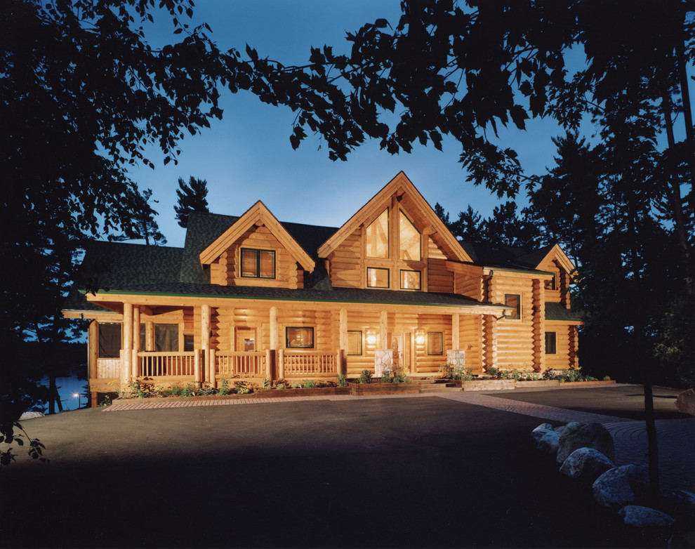 This is an example of a large country two-storey brown exterior in Vancouver with wood siding and a gable roof.